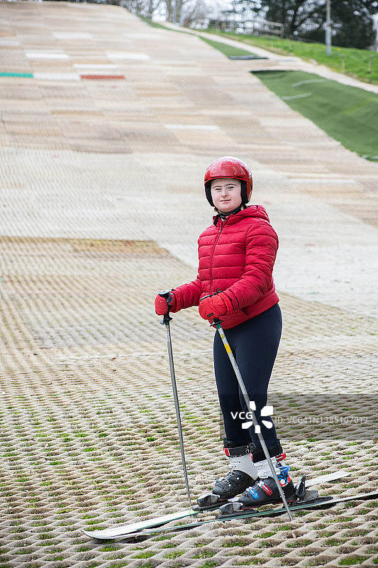 在旱雪滑雪道上的患有唐氏综合征的年轻女士肖像图片素材