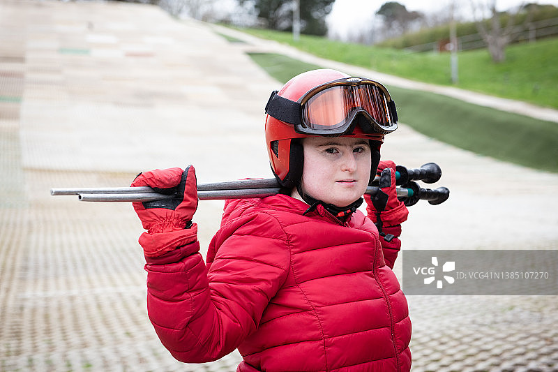 在旱雪滑雪道上的患有唐氏综合征的年轻女士肖像图片素材