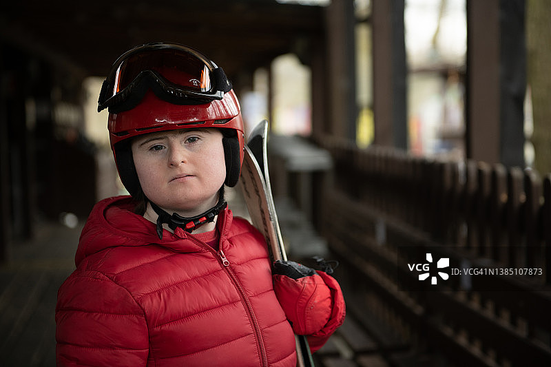 在旱雪滑雪道上的患有唐氏综合征的年轻女士肖像图片素材
