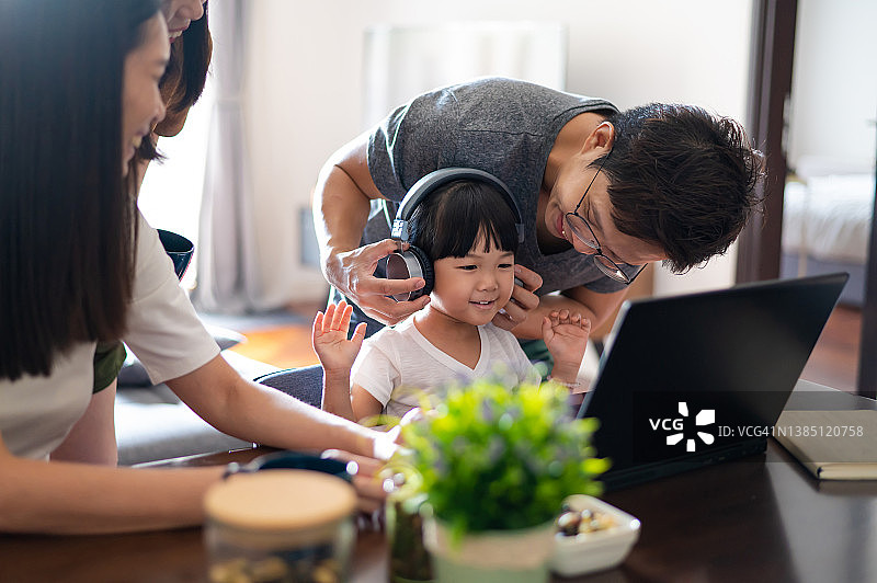 年轻的亚洲小学生在家用笔记本电脑与老师和同学进行视频会议图片素材