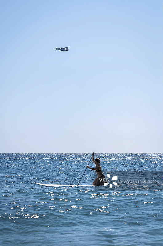 在希腊圣托里尼度假的女人在飞机下划桨图片素材