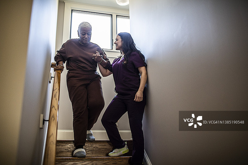 居家护士帮助年长妇女下楼图片素材