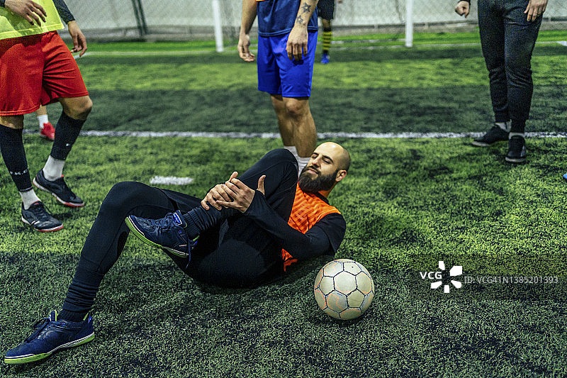 足球运动员抱着受伤的腿图片素材