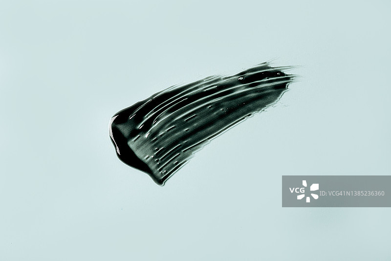 白色背景上的黑色面霜或泥面膜涂抹痕迹。图片素材