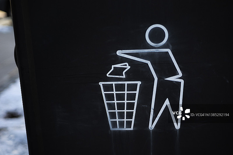 在公共人行道上将垃圾扔进垃圾箱的人的图案图片素材