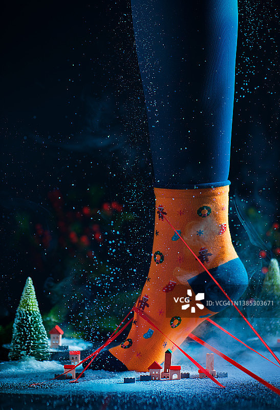 站在小镇里的脚上的圣诞袜，格列佛概念，节日静物图片素材