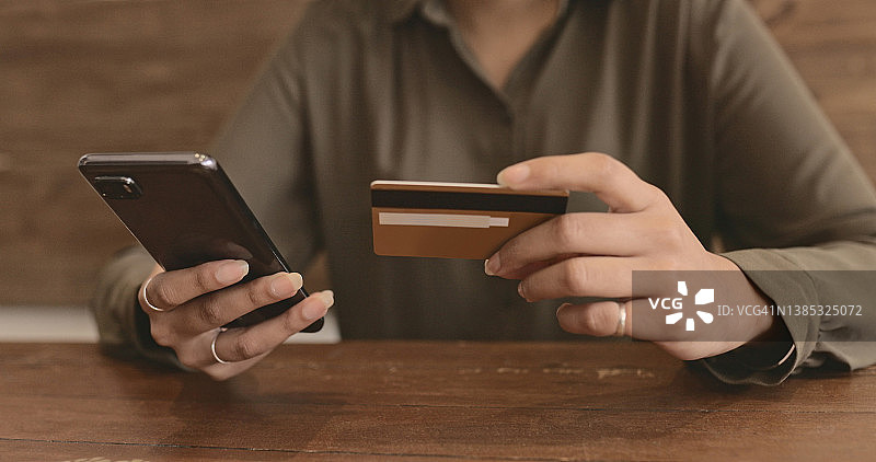 女人在咖啡馆使用智能手机进行在线支付图片素材