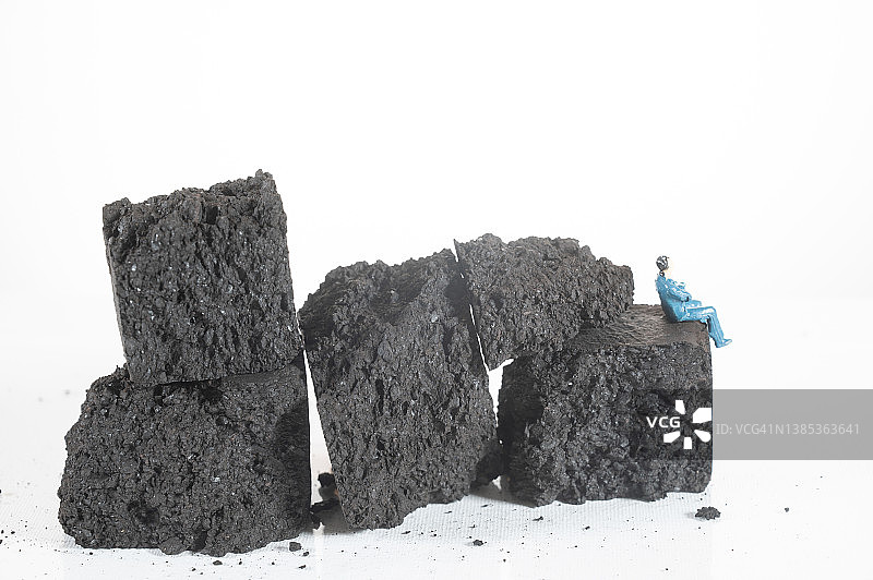 一个小雕像坐在煤山上图片素材