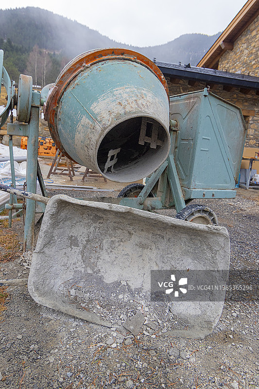 建筑工地中非常脏的泥浆独轮车和水泥搅拌机图片素材