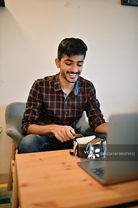 通过笔记本电脑视频通话庆祝生日的年轻男子图片素材