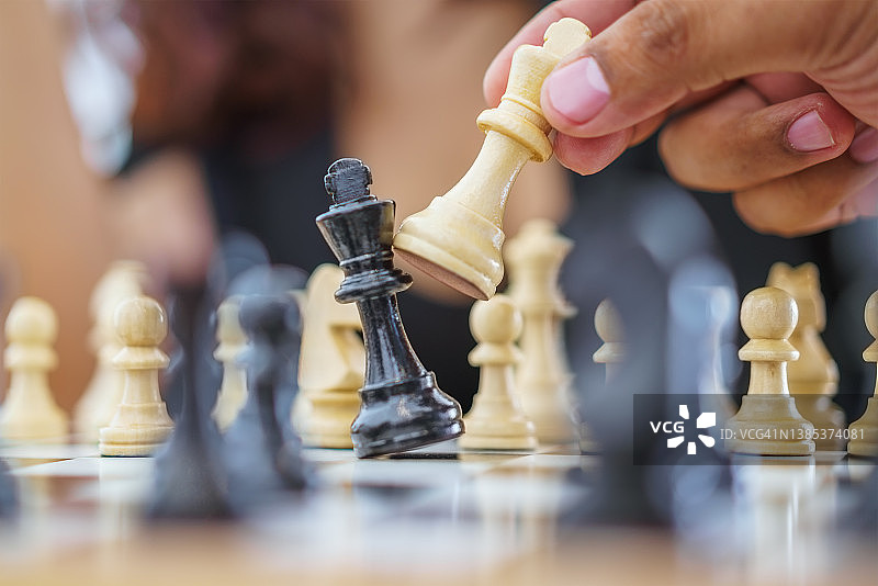 玩家在棋盘上移动白色棋子的手图片素材