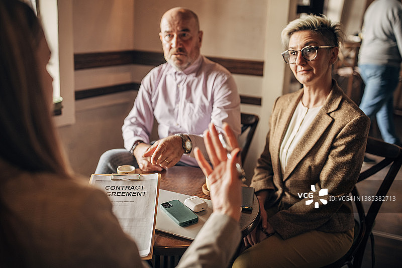 在咖啡馆与房地产经纪人会面的夫妇图片素材