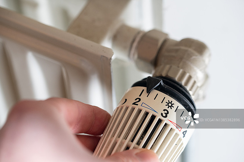 调低暖气：调低散热器上的恒温器以节省能源，应对燃气价格上涨图片素材
