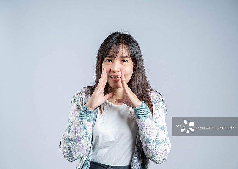 在灰色背景前呼喊的女性肖像图片素材