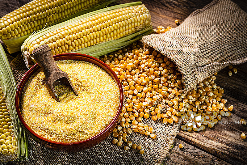 乡村木桌上的玉米干、玉米棒和玉米粉图片素材