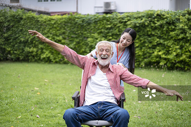 护士在后院照顾坐轮椅的老年男性图片素材