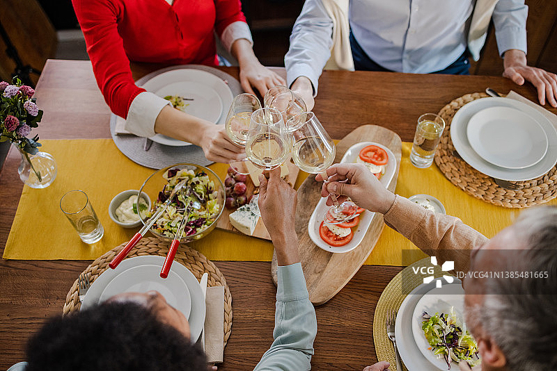 朋友们在晚餐时敬酒的高角度视图图片素材
