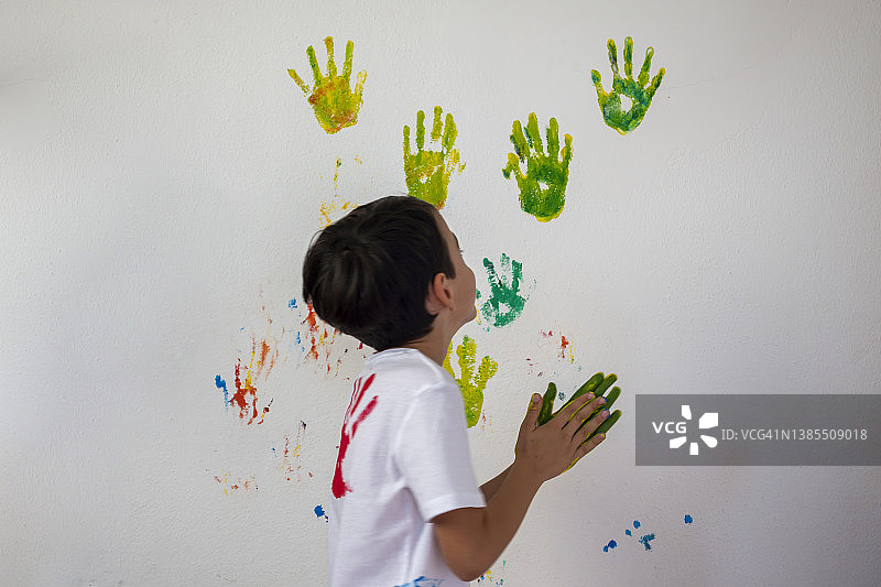 男孩在他的手上显示彩色颜料图片素材