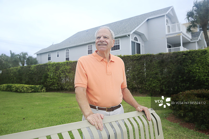 在公园里快乐站立的年长白人，留着胡须，穿着色彩鲜艳的上衣图片素材