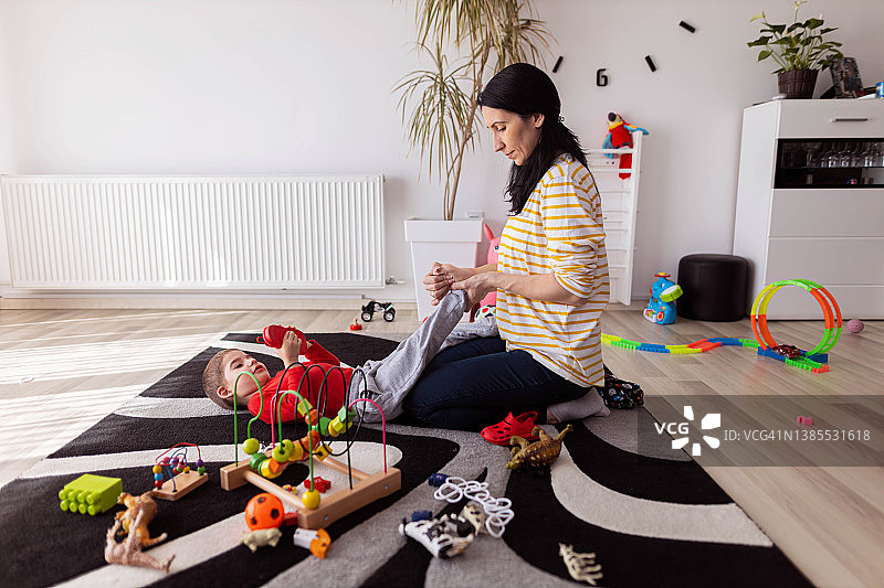 母亲早上帮助儿子做运动图片素材