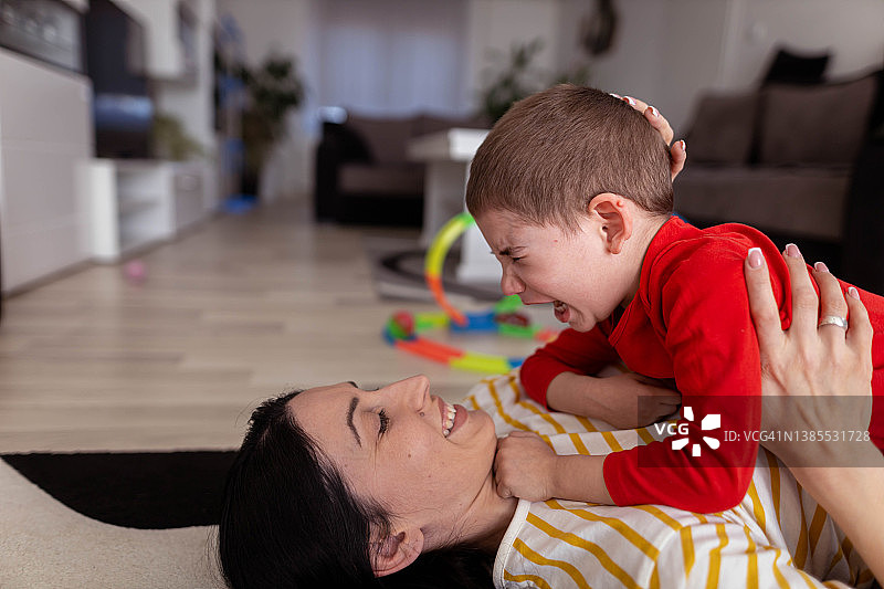 男孩哭泣，妈妈抱着他图片素材