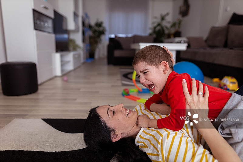 男孩哭泣，妈妈抱着他图片素材