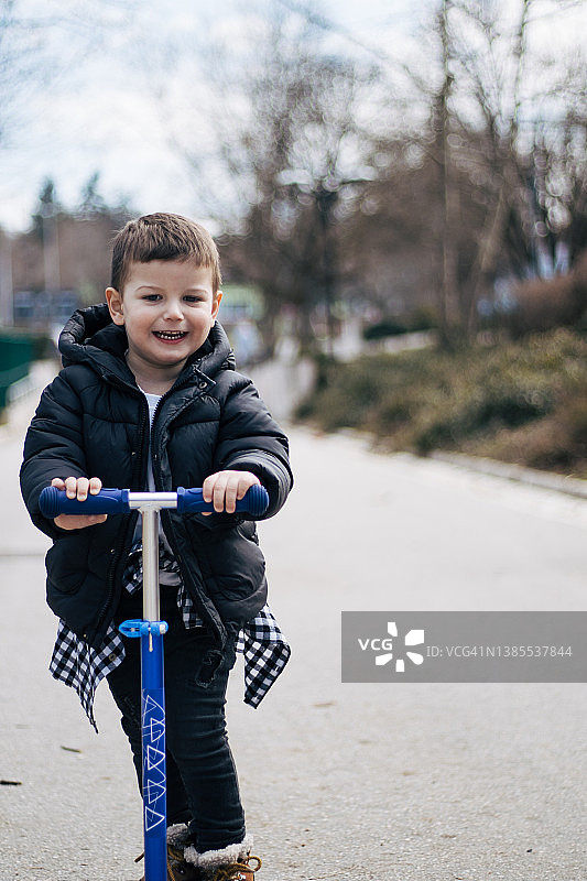 骑滑板车的小男孩图片素材