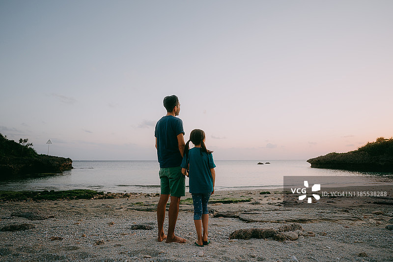 黄昏时分，父亲和孩子在海滩上图片素材