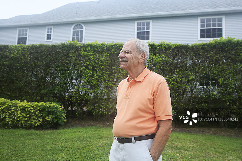 在公园里快乐站立的年长白人，留着胡须，穿着色彩鲜艳的上衣图片素材