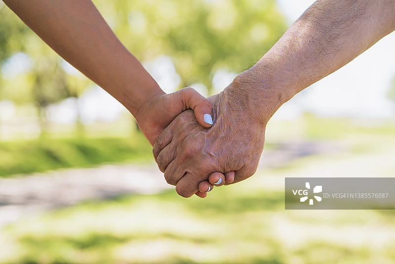 亚裔美国父亲和女儿手牵手的特写图片素材