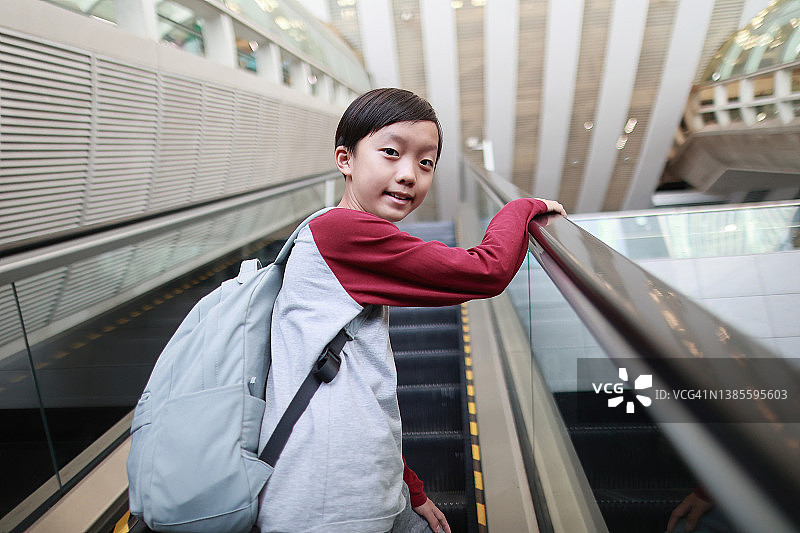 乘坐自动扶梯的男孩图片素材