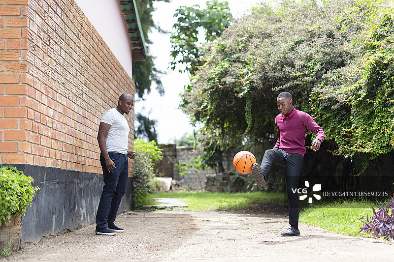 青少年在院子里向父亲踢球图片素材