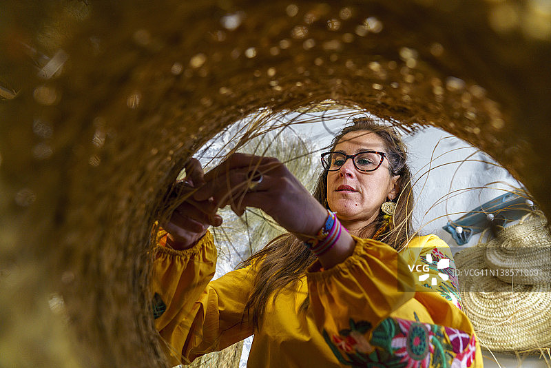 用手加工西班牙针茅草的妇女图片素材