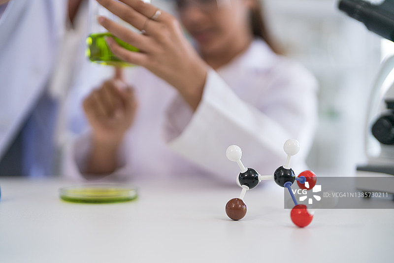 在化学实验室里拿着葡萄糖分子模型的理科小学生图片素材