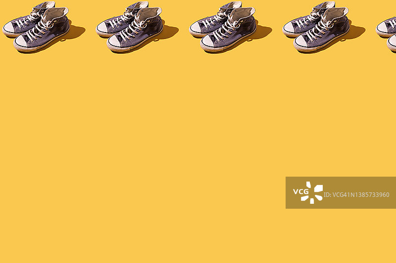 黄色背景上的老式蓝色篮球鞋纹理图案，时尚休闲复古鞋概念图片素材