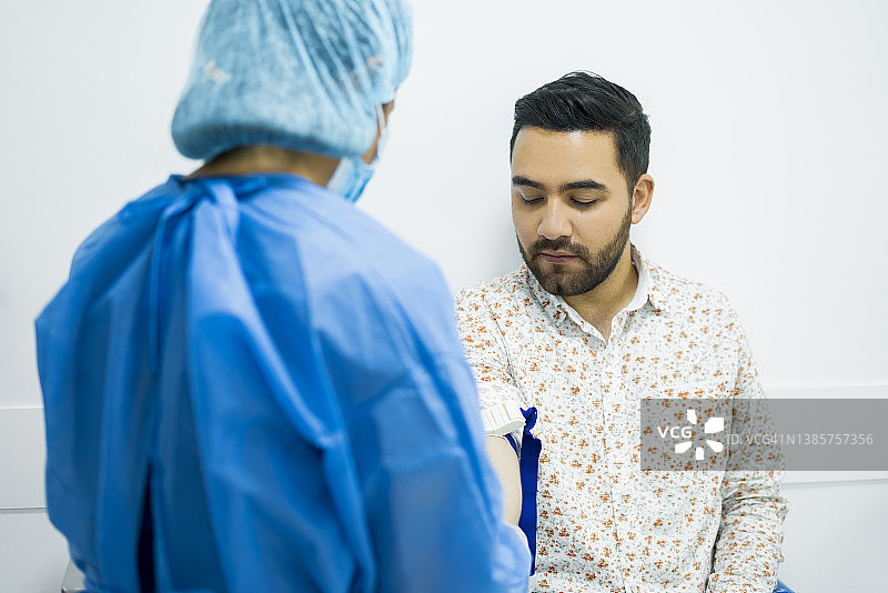 专业护士在诊所工作，正在为患者抽血以进行实验室样本化验图片素材