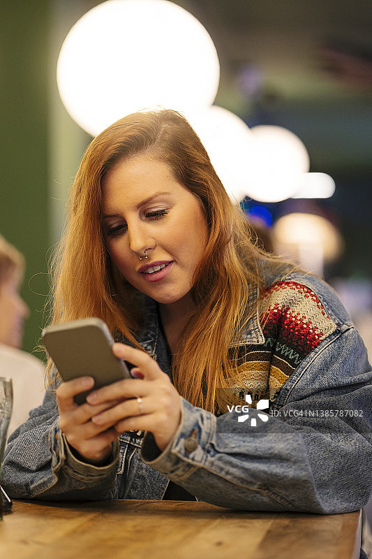 在咖啡店使用智能手机的女人图片素材