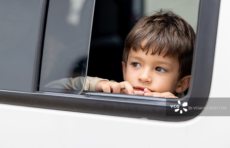 在车里看着打开的窗户的男孩图片素材