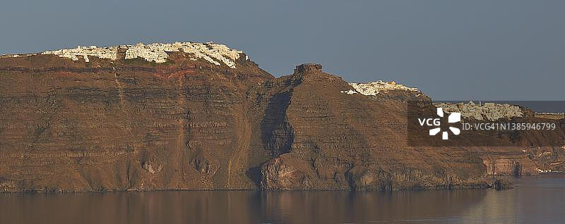 从伊亚眺望火山口到悬崖的景色，伊莫洛维里，菲罗斯特法尼，费拉，悬崖上的村庄，天蓝色无云，海面平静而黑暗，伊亚，圣托里尼岛，基克拉泽斯，希腊图片素材