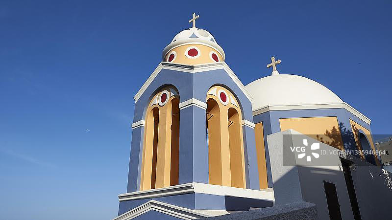晨光、钟楼和圣约翰浸信会天主教堂的圆顶，菲拉，圣托里尼岛，希腊基克拉泽斯图片素材