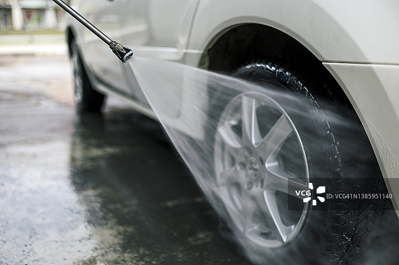 用软管洗车的路人图片素材