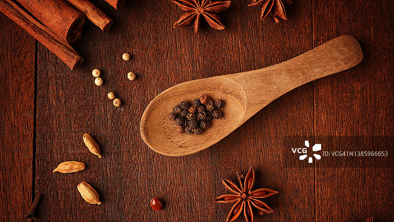 木质背景上的黑胡椒，平铺图片素材