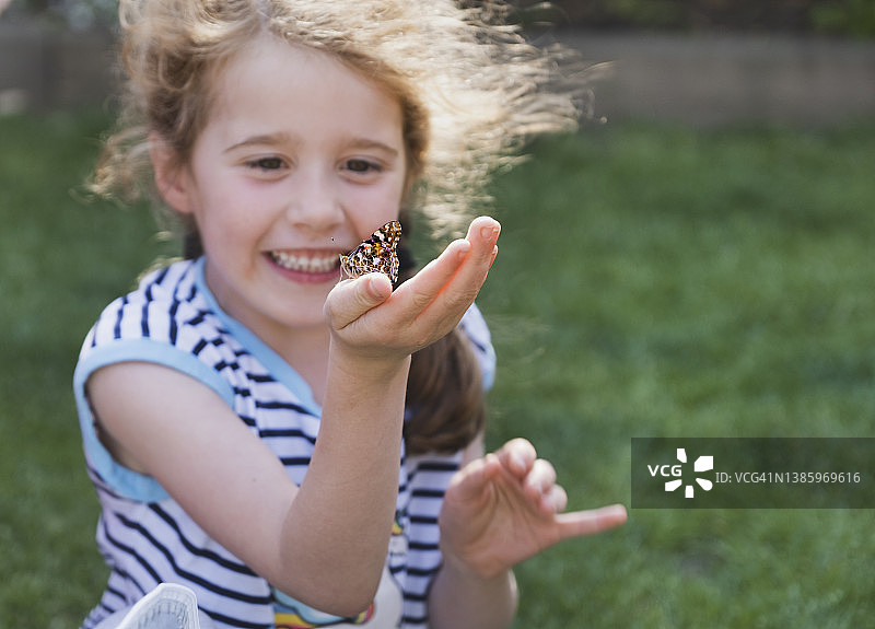 快乐的女孩拿着蝴蝶图片素材