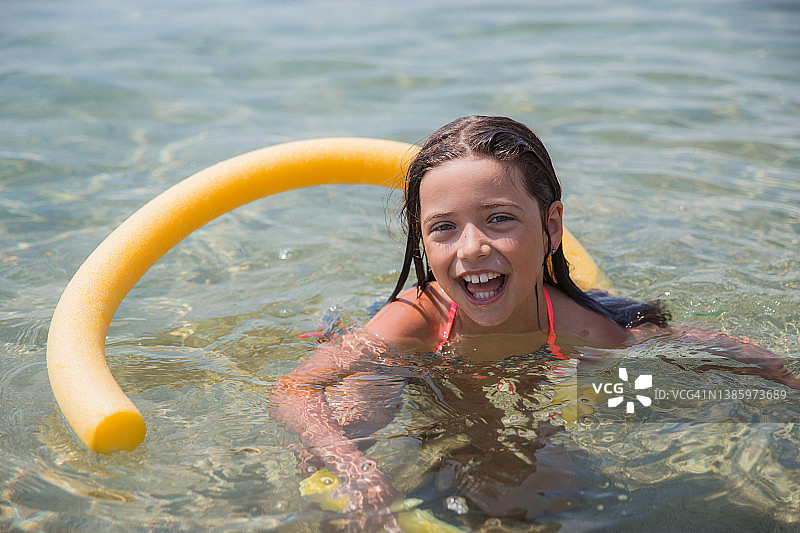 快乐女孩使用游泳浮板游泳图片素材