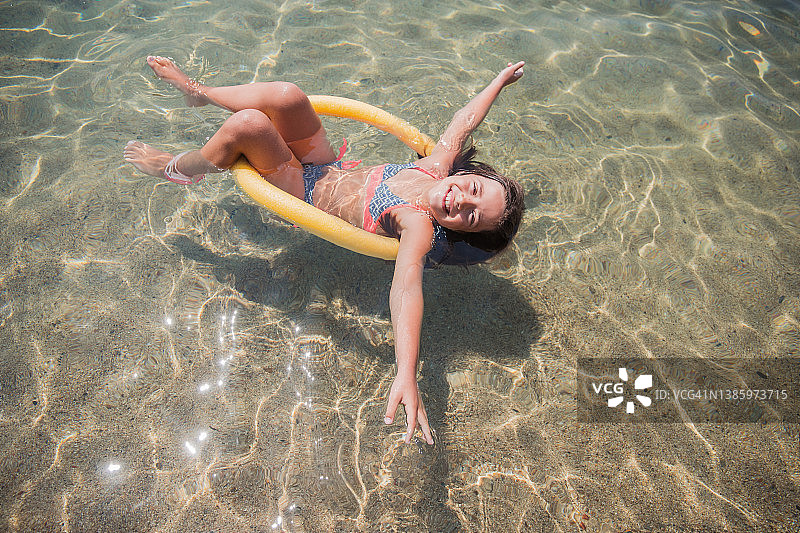 用漂浮板在海上漂浮的快乐女孩图片素材
