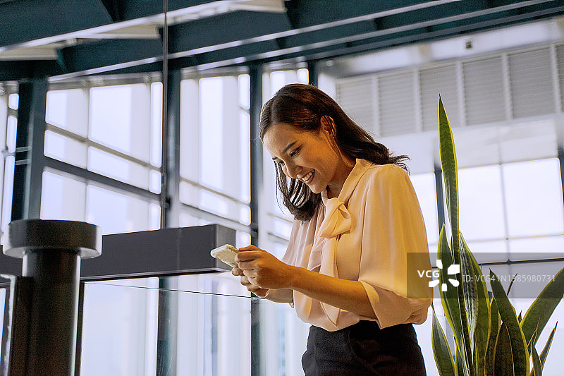 商务女性在办公室使用智能手机，享受独处时光图片素材
