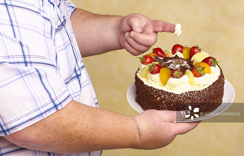 肥胖男人吃奶油蛋糕图片素材