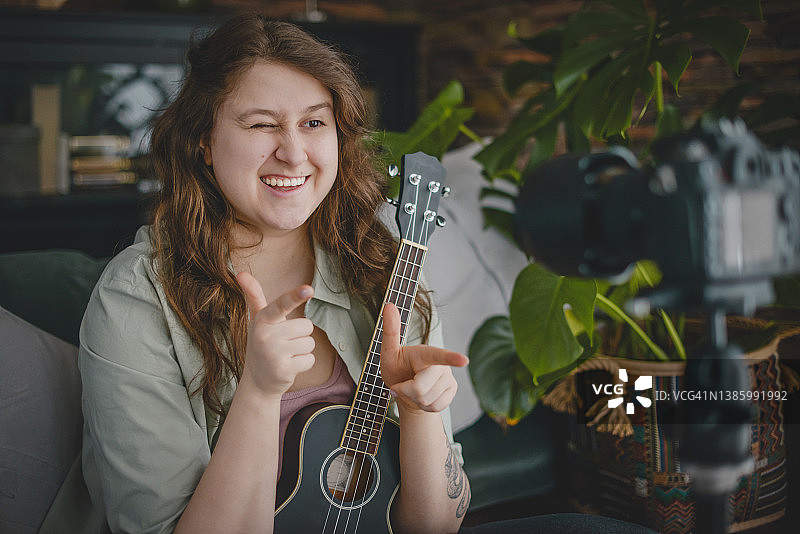 女子通过网络视频教程进行吉他教学图片素材