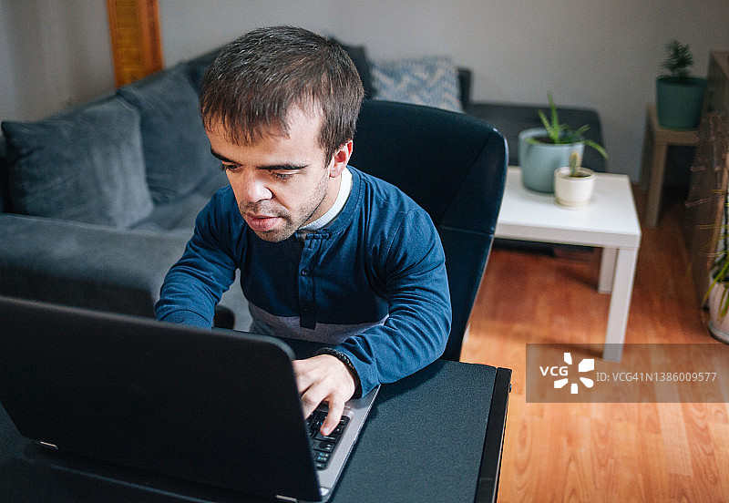 在家工作的患有侏儒症的年轻男人图片素材