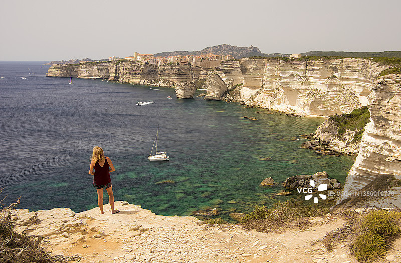 女人欣赏法国科西嘉岛博尼法乔村庄及其悬崖图片素材
